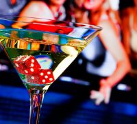 Martini glass with dice at bottom, sitting on casino gambling table