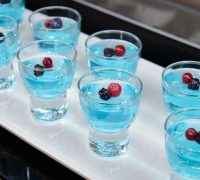 Blue jelly with berries in a glass on a white plate